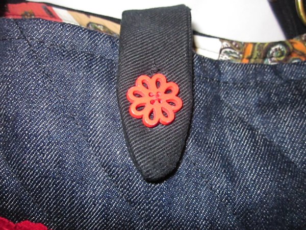 A táska helyes kis virág gombbal záródik