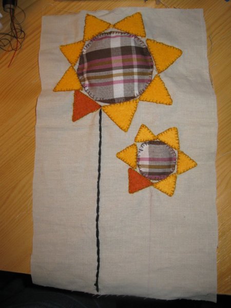 A napcsik szára a fekete hímzőfonallal készült, láncöltéssel.